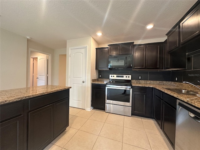 kitchen featuring a textured ceiling, stone countertops, sink, and stainless steel appliances