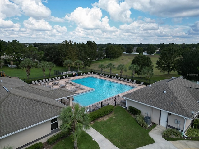 view of swimming pool with a yard and central AC unit