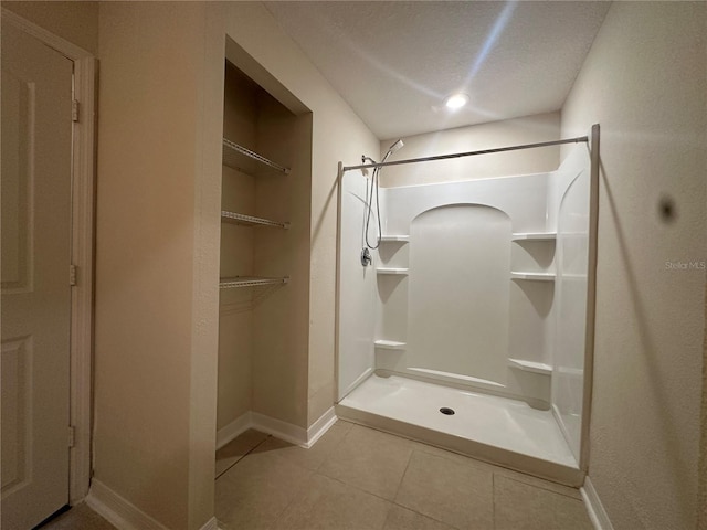 bathroom featuring a shower, a textured ceiling, and tile patterned floors