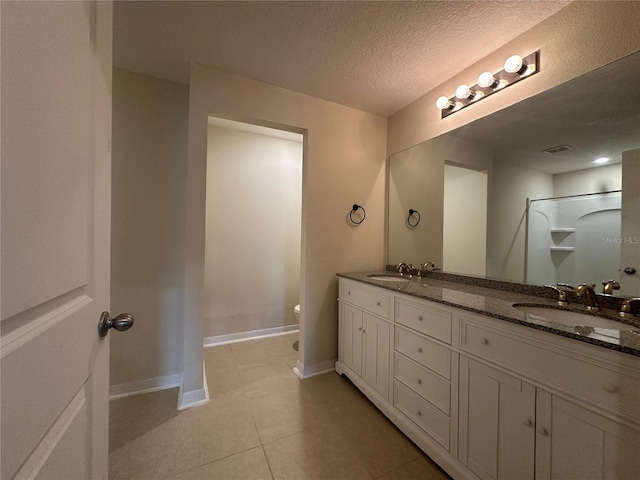 bathroom featuring walk in shower, tile patterned floors, a textured ceiling, toilet, and vanity