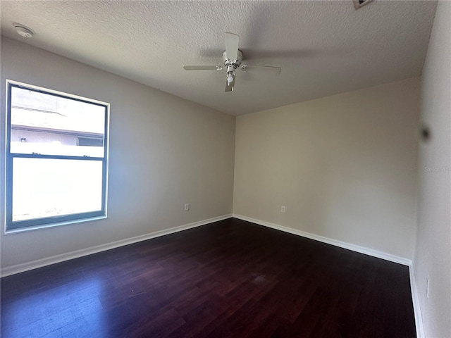 spare room with ceiling fan, dark wood-type flooring, and a textured ceiling