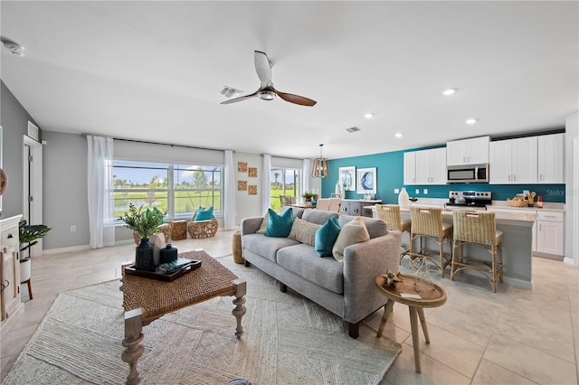 living room with ceiling fan and light tile patterned floors