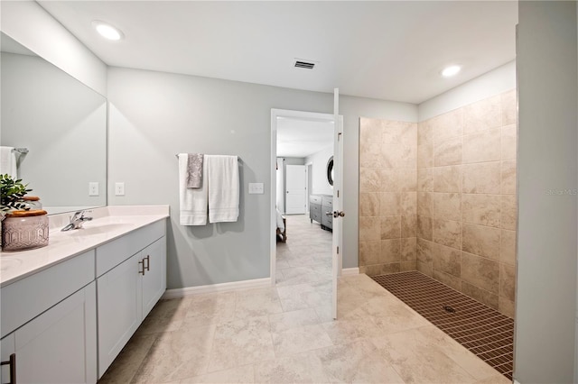 bathroom with vanity and tiled shower