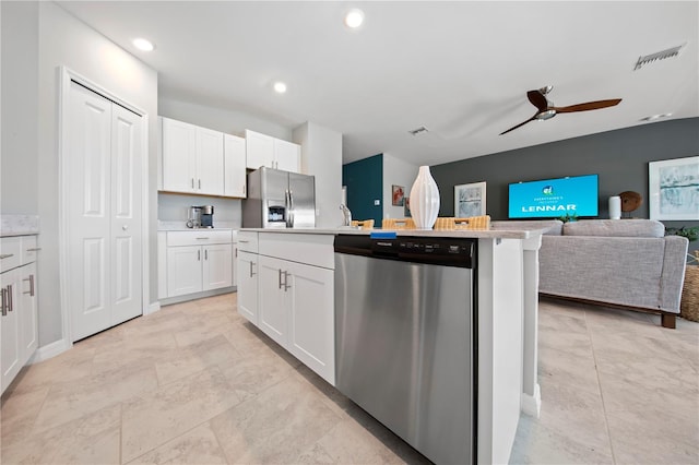 kitchen featuring a center island with sink, ceiling fan, stainless steel appliances, and white cabinets