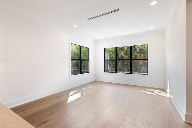 empty room with ornamental molding and light wood-type flooring