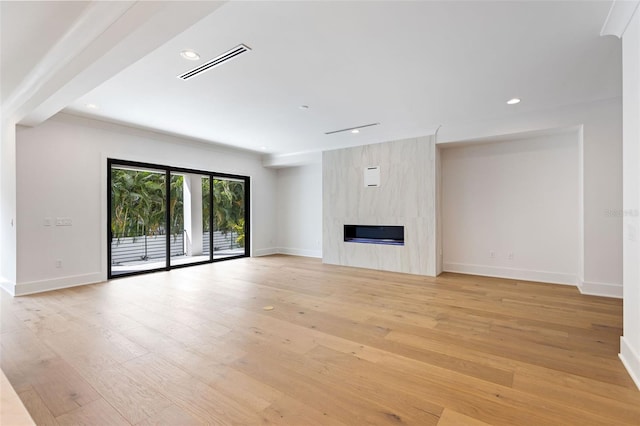 unfurnished living room with light wood-type flooring and a fireplace