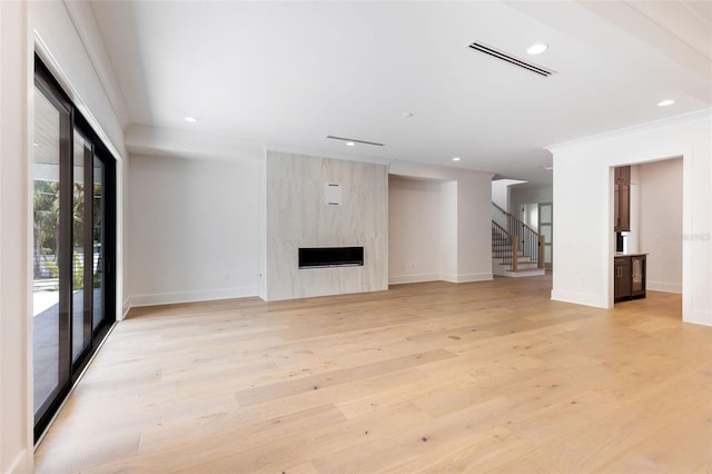 unfurnished living room featuring a high end fireplace and light hardwood / wood-style flooring