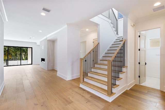 staircase featuring hardwood / wood-style flooring and crown molding