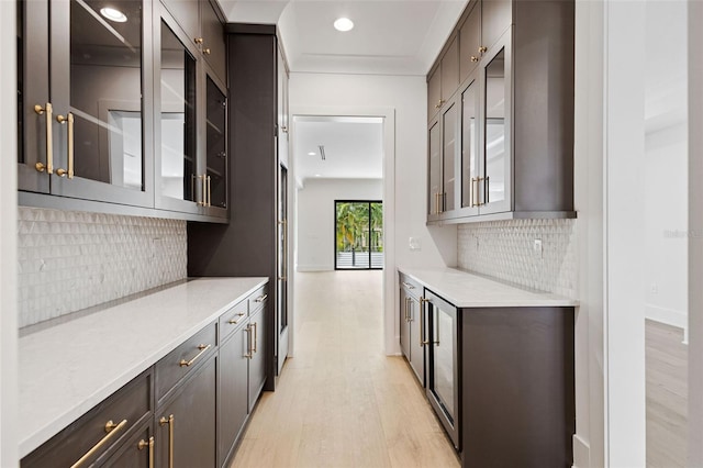 bar featuring light hardwood / wood-style flooring and backsplash