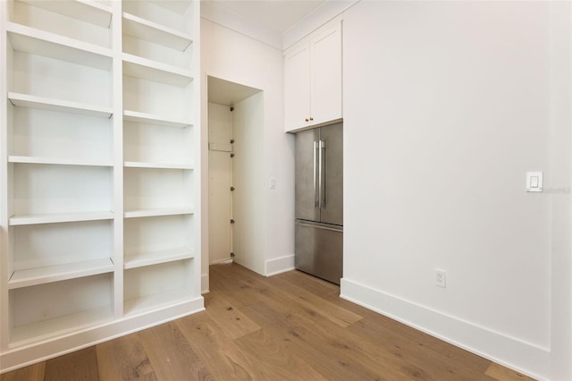 interior space with white cabinetry, light wood-type flooring, and high end refrigerator