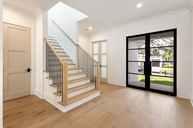 interior space featuring crown molding and light hardwood / wood-style flooring