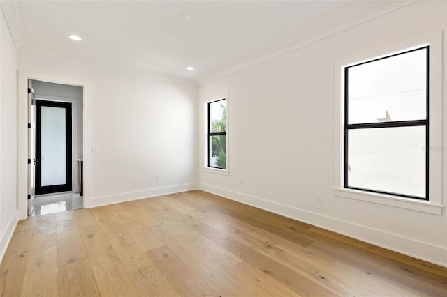 unfurnished room with light wood-type flooring and crown molding