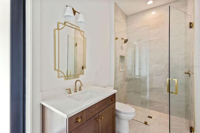 bathroom with a shower with shower door, vanity, and toilet