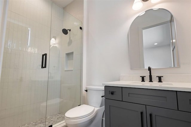 bathroom featuring an enclosed shower, vanity, and toilet