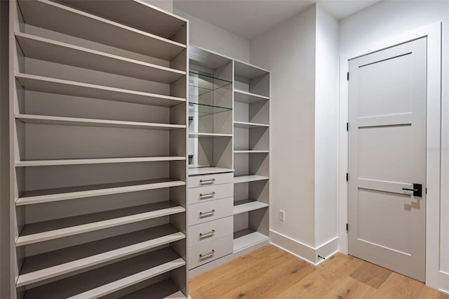 walk in closet with light hardwood / wood-style floors