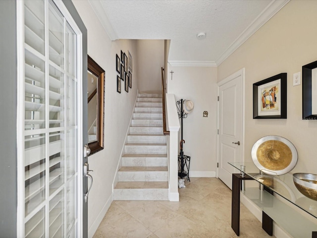 foyer entrance with ornamental molding and a textured ceiling