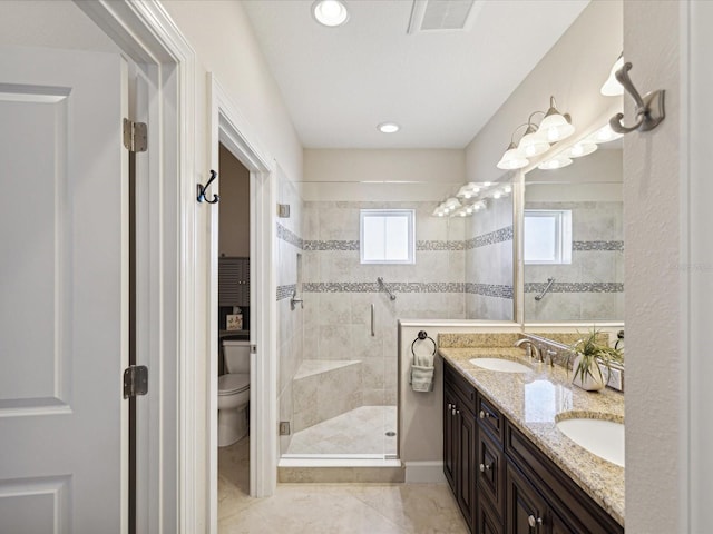 bathroom featuring a shower with door, vanity, toilet, and tile patterned floors