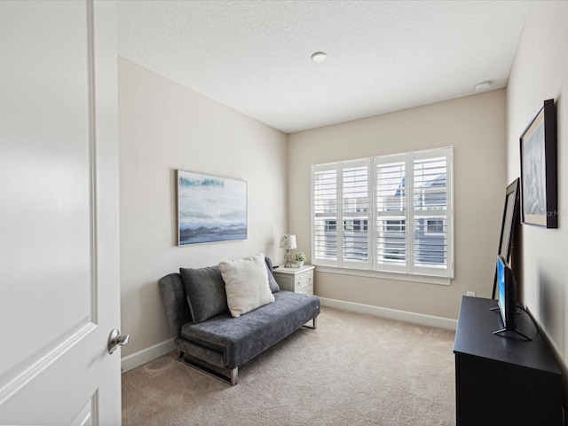 living area featuring light carpet and a textured ceiling