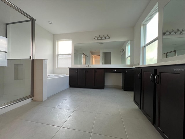 bathroom featuring plus walk in shower, vanity, and tile patterned floors