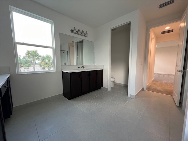 bathroom featuring tile patterned flooring, vanity, and toilet