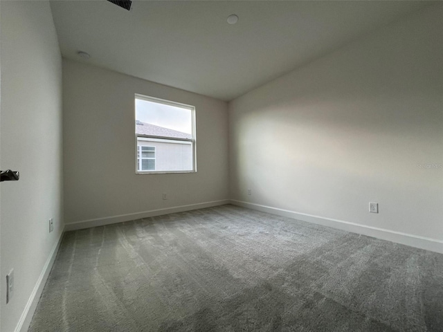 empty room with carpet flooring and vaulted ceiling