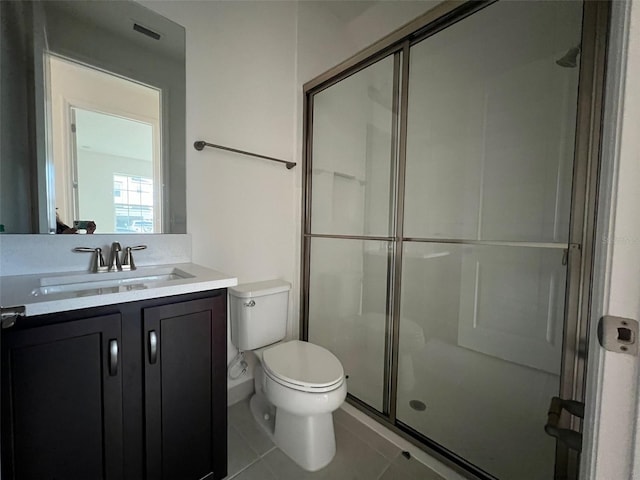 bathroom with tile patterned flooring, vanity, toilet, and an enclosed shower