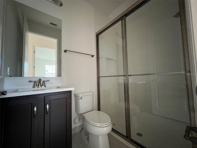 bathroom featuring tile patterned flooring, vanity, an enclosed shower, and toilet