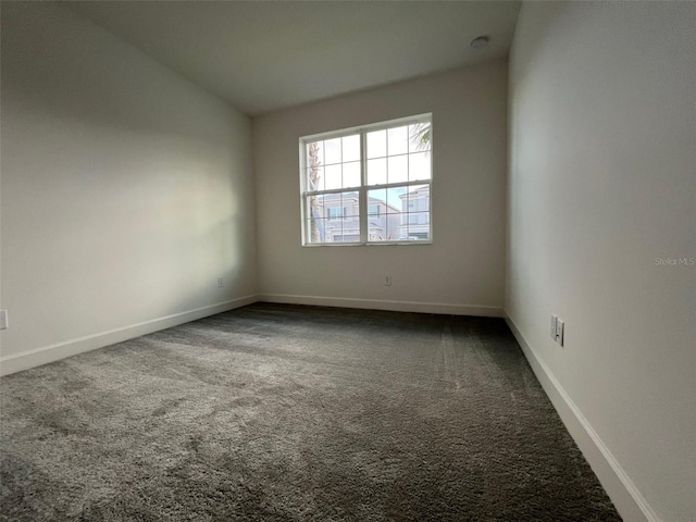 carpeted empty room featuring lofted ceiling