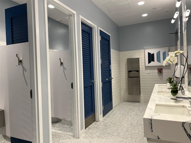 bathroom featuring vanity and tile walls