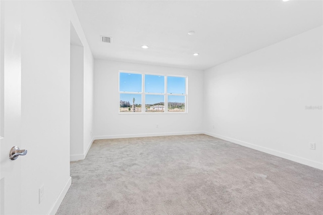 spare room featuring light carpet