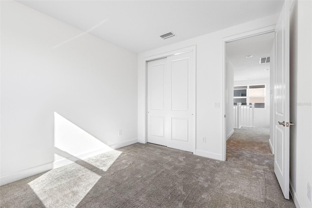 unfurnished bedroom featuring carpet flooring and a closet