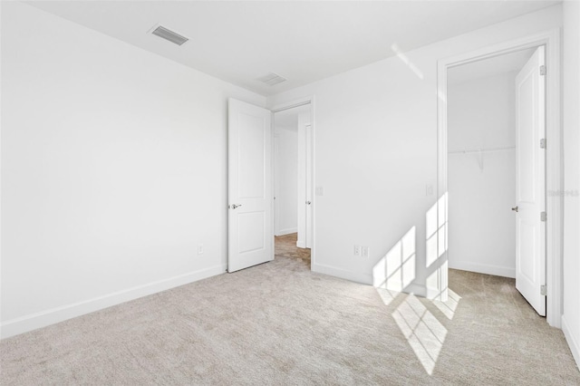 unfurnished bedroom featuring light carpet and a closet