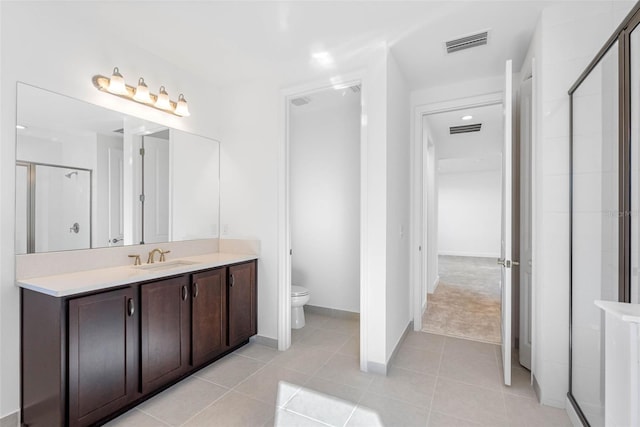 bathroom with vanity, tile patterned flooring, toilet, and walk in shower