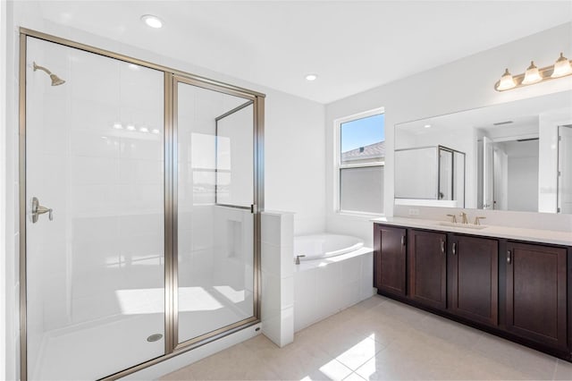 bathroom with tile patterned flooring, independent shower and bath, and vanity