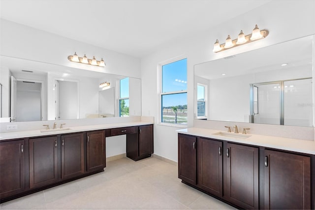 bathroom featuring vanity, a shower with shower door, and tile patterned floors