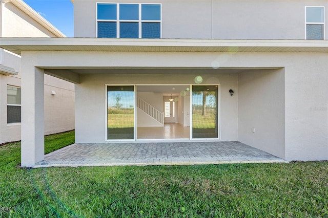 rear view of house with a patio area and a lawn