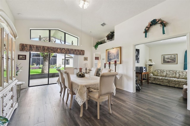 dining area with dark hardwood / wood-style floors, a textured ceiling, and high vaulted ceiling