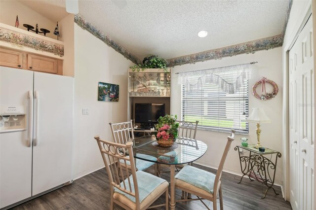 dining space featuring a textured ceiling and dark hardwood / wood-style flooring