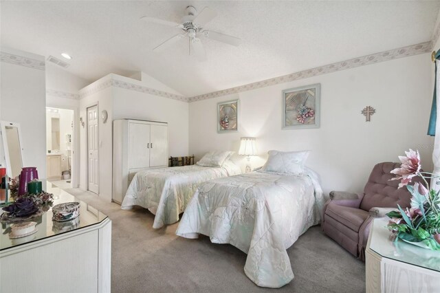 carpeted bedroom featuring connected bathroom, vaulted ceiling, and ceiling fan