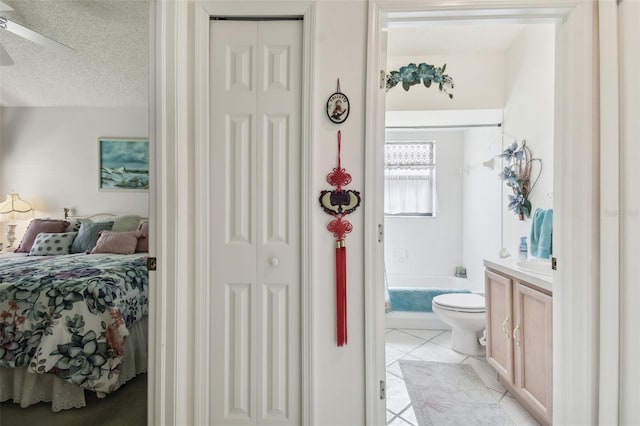 bathroom featuring toilet, tile patterned flooring, a washtub, vanity, and a textured ceiling