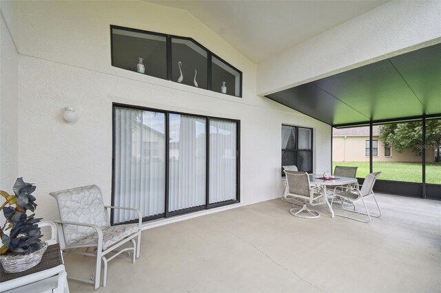 sunroom featuring vaulted ceiling and a healthy amount of sunlight