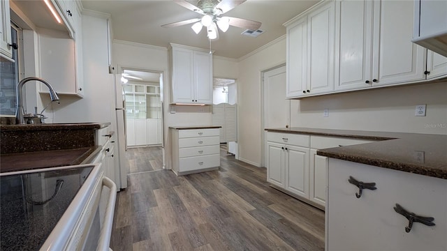 kitchen with range, ornamental molding, white cabinets, and wood finished floors