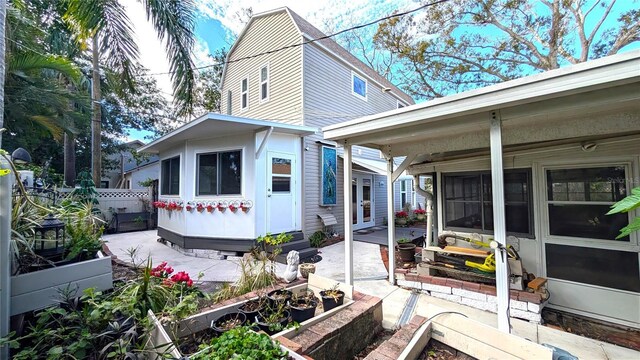 view of side of property featuring a vegetable garden, a patio area, and fence