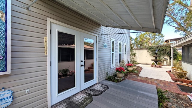 deck with a patio area, fence, and french doors