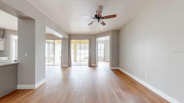 unfurnished living room with ceiling fan and light wood-type flooring