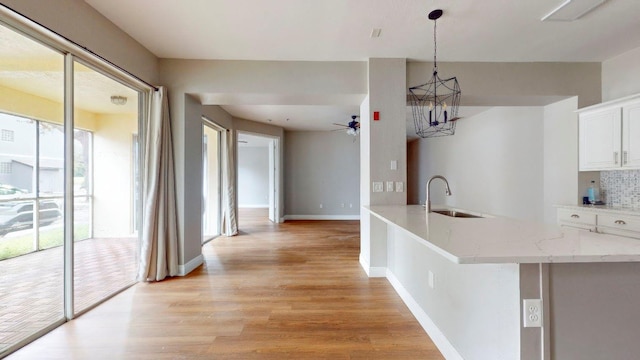 kitchen with plenty of natural light, white cabinets, and sink