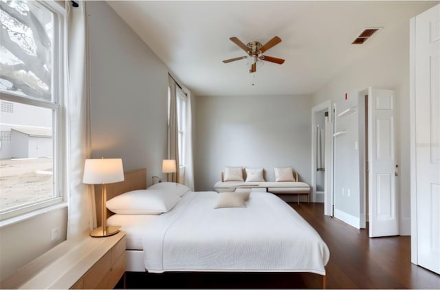 bedroom with dark hardwood / wood-style flooring, multiple windows, and ceiling fan