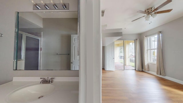 bathroom featuring a shower with door, hardwood / wood-style flooring, vanity, and ceiling fan