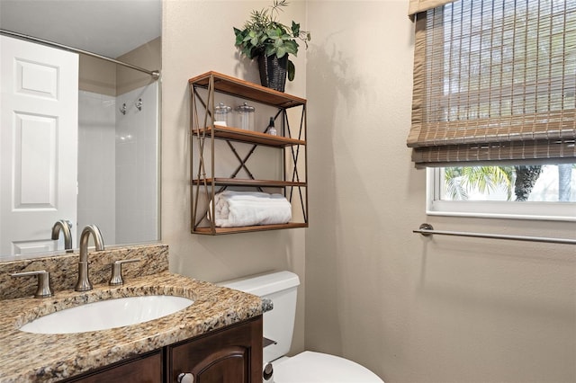 bathroom featuring walk in shower, vanity, and toilet