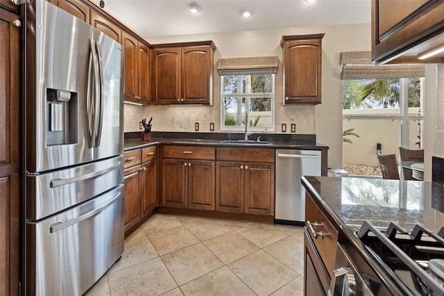 kitchen featuring appliances with stainless steel finishes, sink, tasteful backsplash, and a healthy amount of sunlight